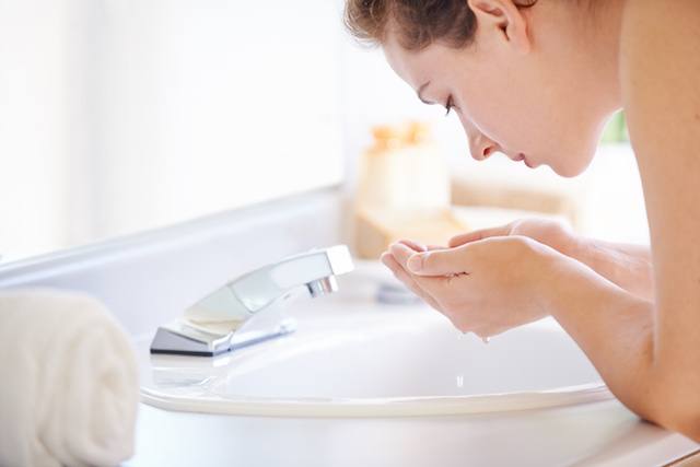 Femme se lavant le visage avec un produit NEUTROGENA® pour avoir la peau nette