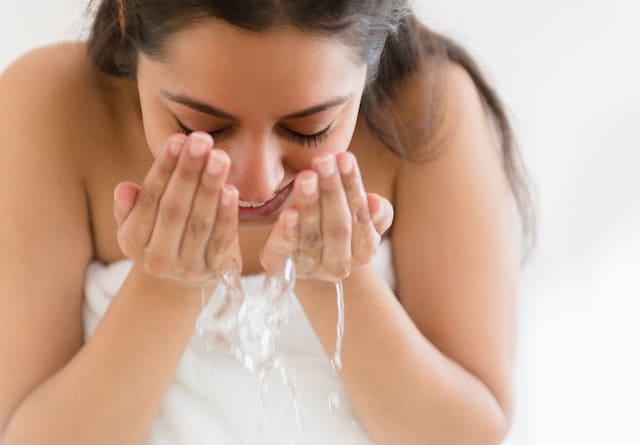 Woman washing her face with NEUTROGENA® products
