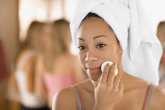 Woman removing makeup with NEUTROGENA® makeup remover & a cotton pad
