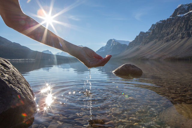 Femme touchant l'eau d'un lac naturel