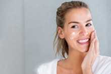Woman moisturizing her skin with NEUTROGENA® products